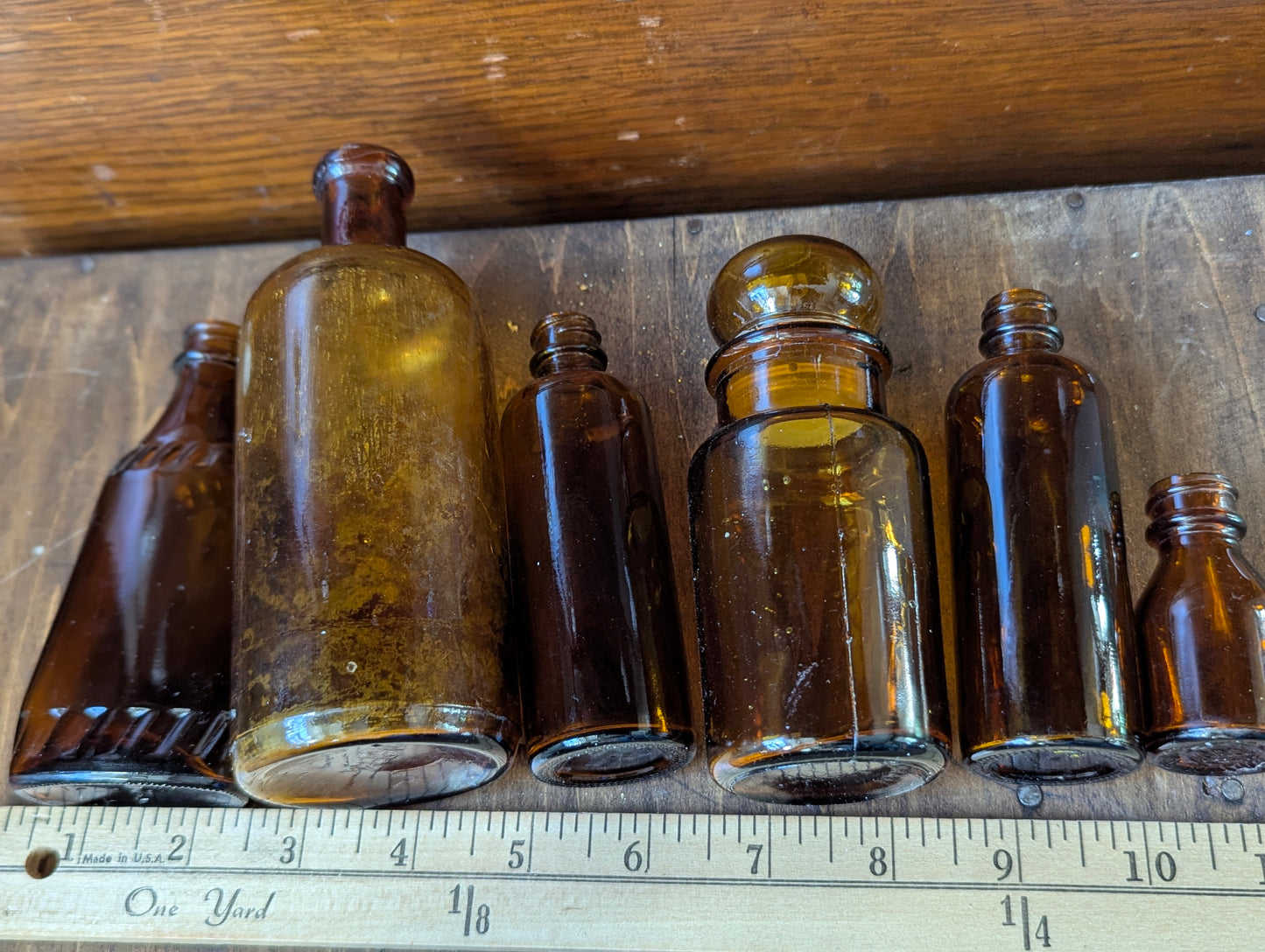 Six old amber glass bottles